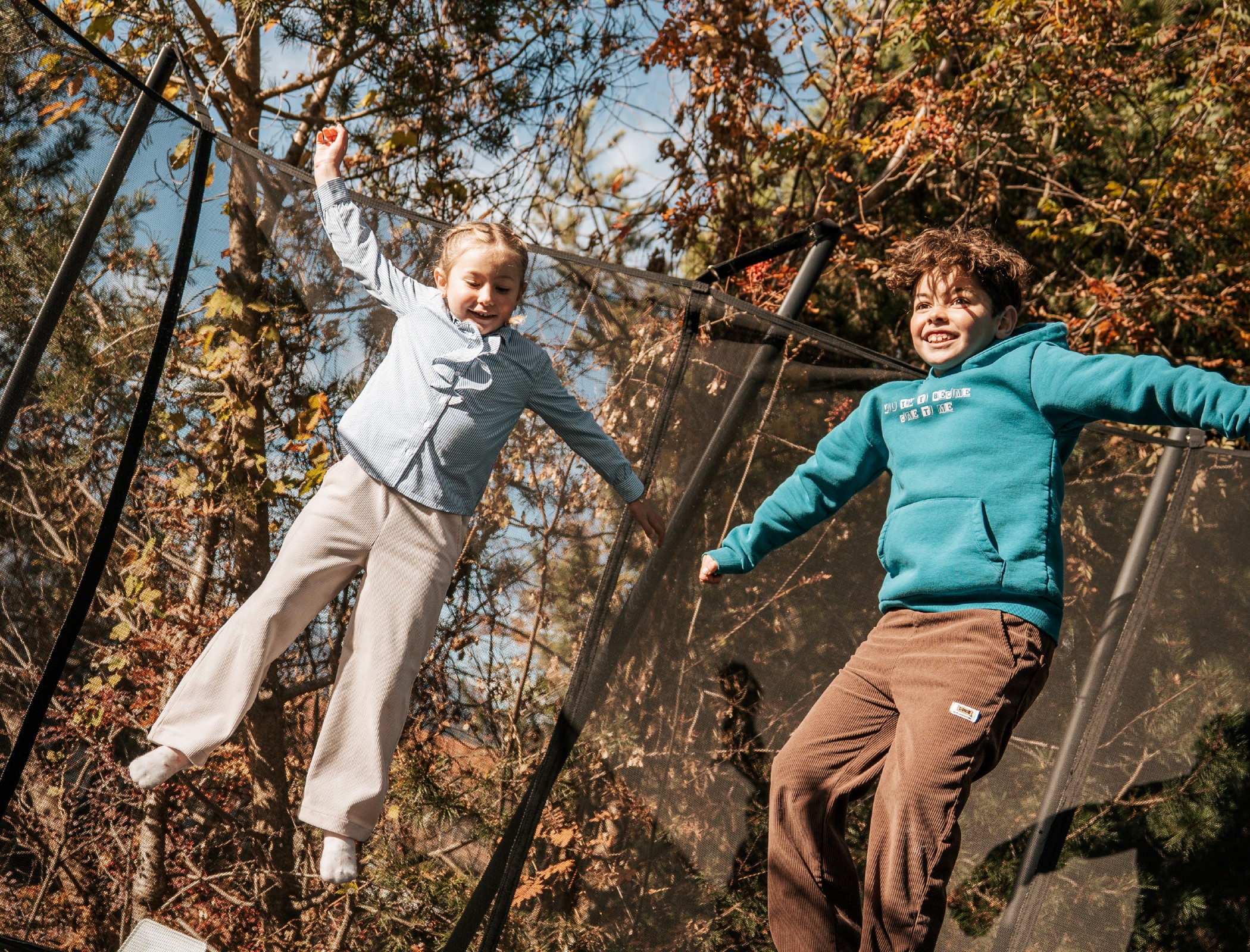 Kind beim Trampolin hüpfen im Herbst