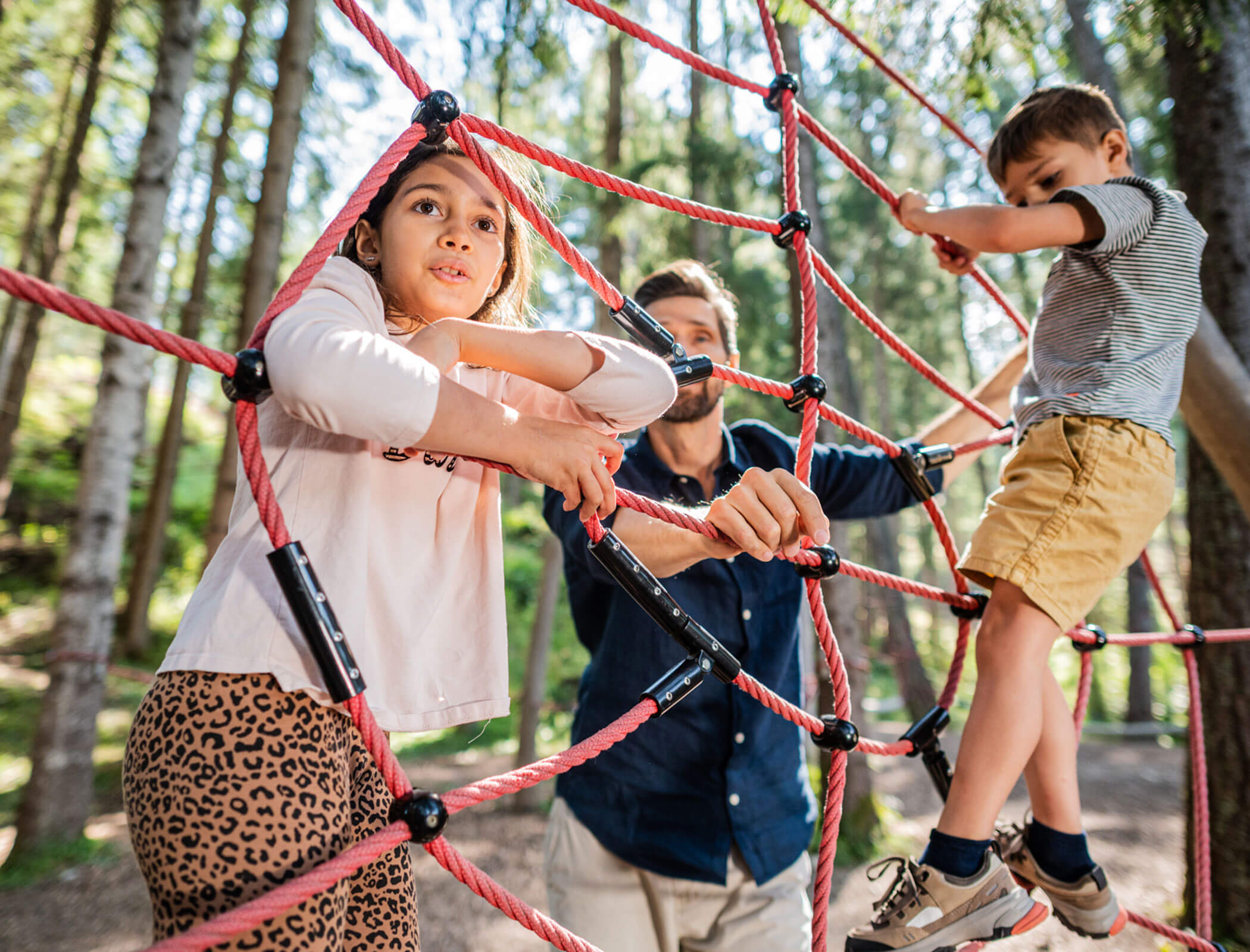 Family playing on the playground in the forest - Hotel Fameli