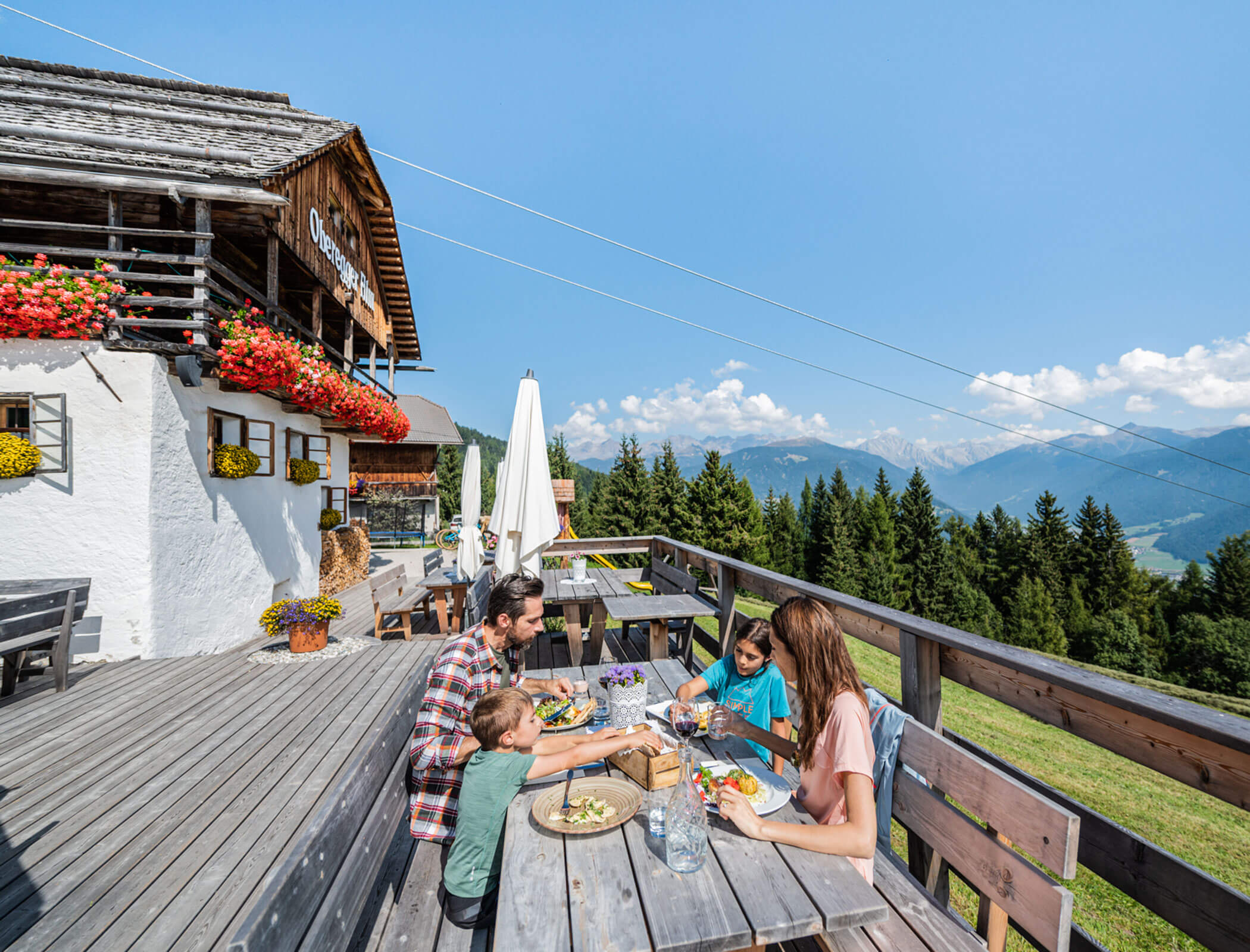 Family enjoying a snack on the Oberegger Alm - Hotel Fameli