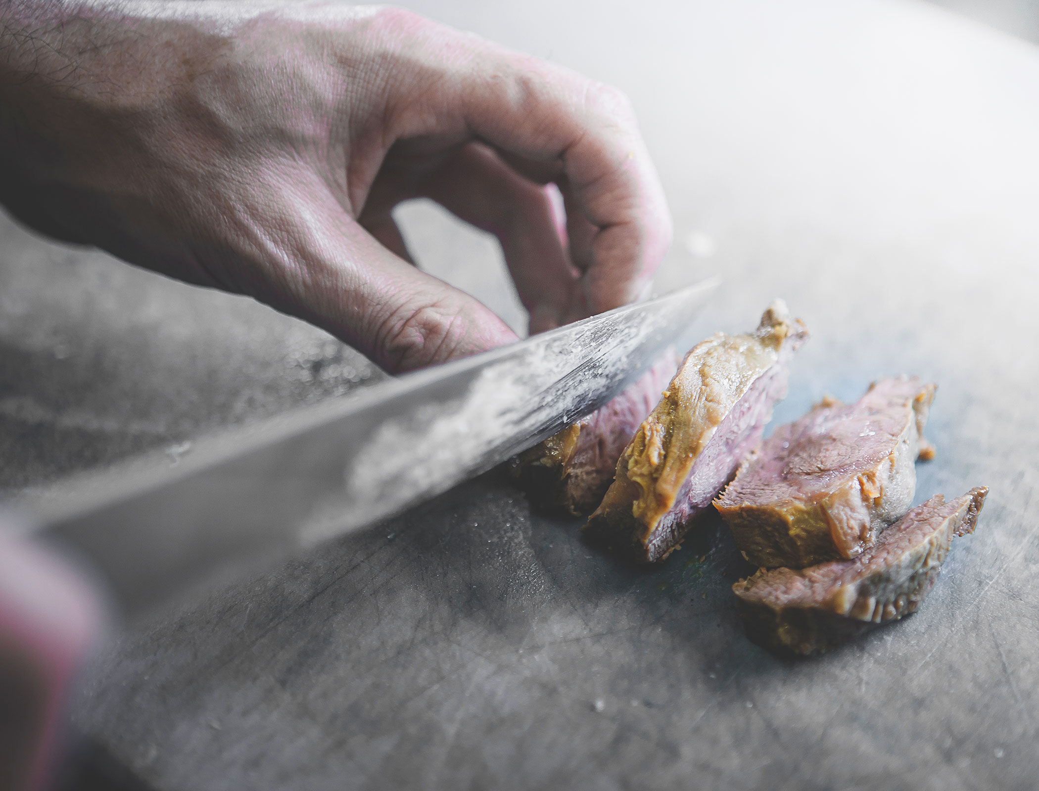 Cook preparing meat - Hotel Fameli