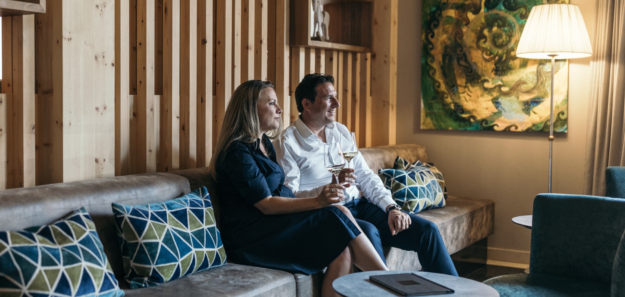 Zwei Personen genießen ein Glas Wein im Lounge Bereich