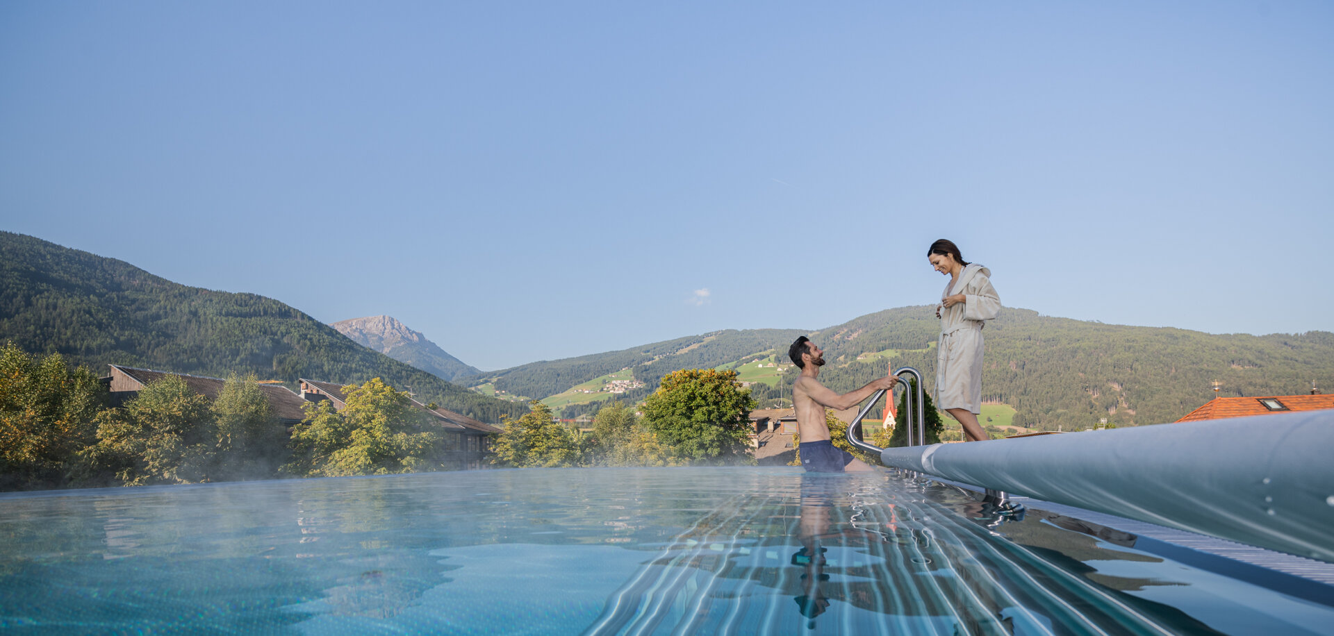 Man gets out of the outdoor pool to woman - Hotel Fameli